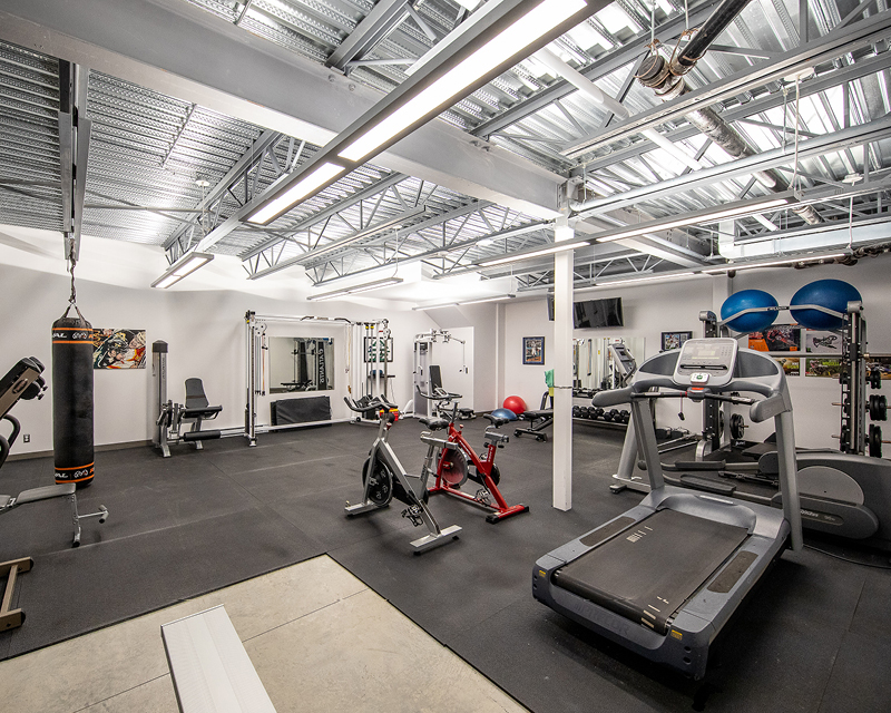 Photo d'une salle de gym et la description dit que l'environnement est stimulant. Photo of a gym room and the photo description says the environment is stimulating.